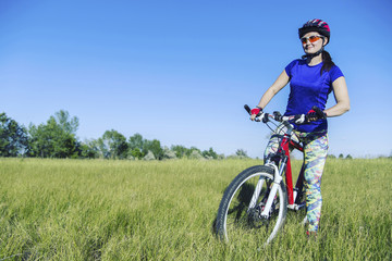 Fototapeta na wymiar Young Woman Riding Mountain Bike in Wilderness.