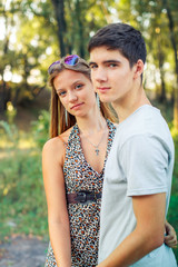 Obraz premium Portraits of beautiful enamored guy and girl. Girl with glasses on head is standing next to boyfriend.
