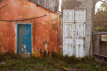 Fototapeta na wymiar Old colored door in abandoned house in countryside