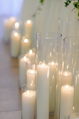 burning candles in glass vases, blur background, selective focus.