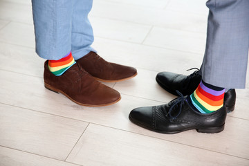 Gay couple with colorful socks on light floor
