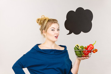 Woman holds shopping basket with vegetables, speech bubble