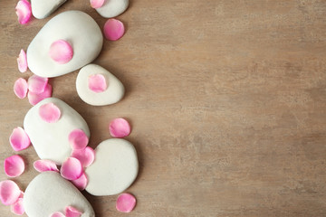 Spa stones and petals on textured background