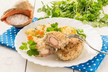 Fish cutlets stuffed with surimi and stewed potatoes with carrots