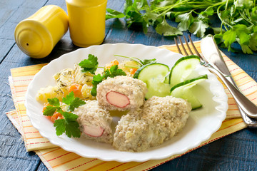 Fish cutlets stuffed with surimi and stewed potatoes with carrots