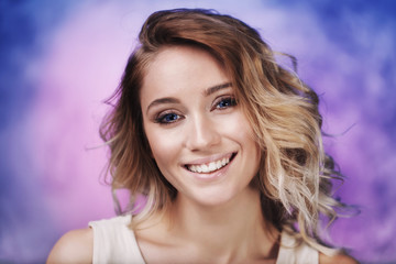 Fototapeta premium Beautiful young girl with blue eyes looking at the camera. Female model portrait in studio closeup