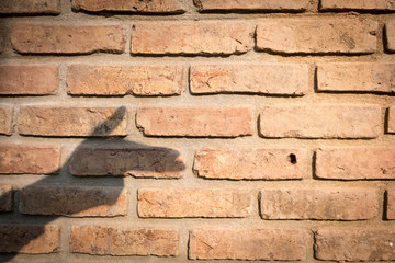 hand silhouette shadow play as gun on old brick wall texture. violence concept Background for design.