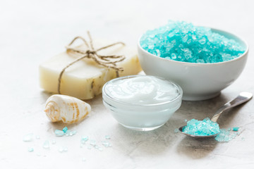 Home cosmetic with cream and blue sea salt on stone background