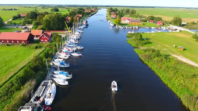 Village near the river. Drone camera flaying over the small village near the river on a countryside on a sunny summer day.