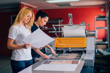 Two young woman working in printing factory