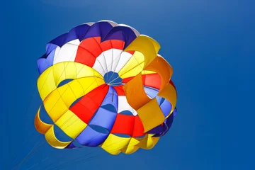 Photo sur Plexiglas Sports aériens Le parachute coloré dans le ciel bleu