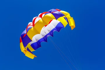Keuken foto achterwand Luchtsport De kleurrijke parachute in de blauwe lucht