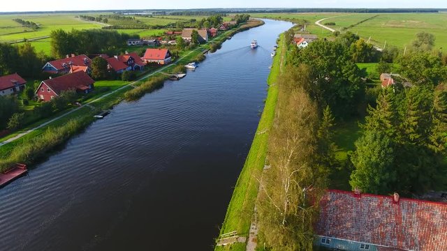 Village near the river. Drone camera flaying over the small village near the river on a countryside on a sunny summer day.
