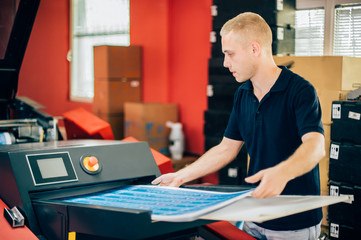 Young man working in printing factory