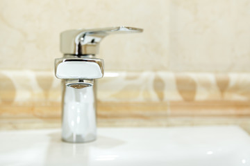 Modern metal faucet in bathroom