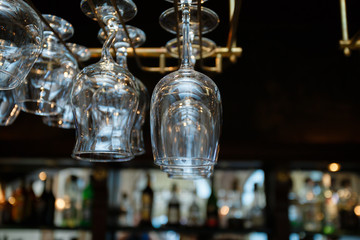 Glasses champagne hangs above the bar counter in the bar. Glasses cocktail hanging glasses over a bar rack.
