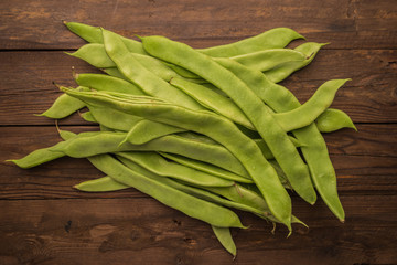 A pile of fresh green beans on table. Green runner beans. Top view
