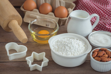 Fototapeta na wymiar Baking ingredients flour, egg, milk, almonds, sugar on wooden table