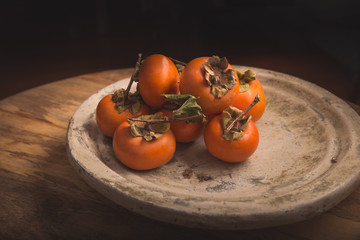 Fresh Persimmon on rustic stone background