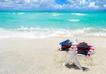 Naklejka premium Patriotic USA background with starfish on the sandy beach