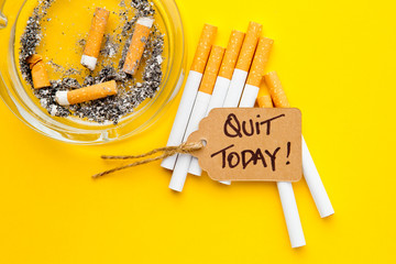 No Smoking - Time to Quit - with cigarettes, ashtray and handwritten tag on yellow background
