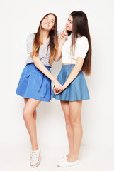 Full body portrait of two happy  girls over white background