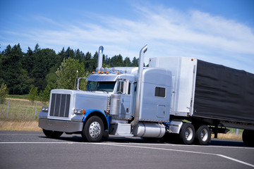 Fototapeta na wymiar Big classic semi truck rig tall pipes custom trailer black