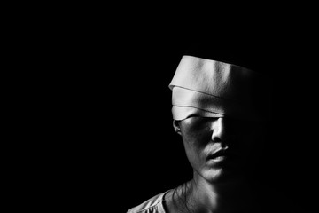 woman with bandages wrapped around her head standing in the dark