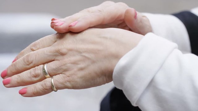 Mature woman moisturising her hands with cream 