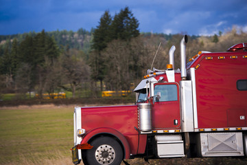 Bright red classic big rig semi trick side view