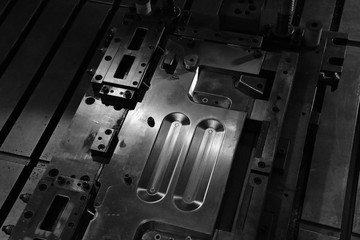 Sheet Metal Stamping Tool Die for Automotive Precision Parts on The Numerical Control Milling Machine Table. Tandem Stamping System. At a High Quality Technology Factory. Black and White Photography.