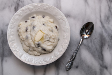  Semolina porridge with raisins on marble cutting board, vintage silver plate spoon