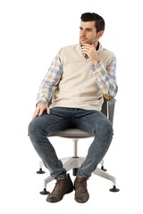 Young man sitting in swivel chair thinking