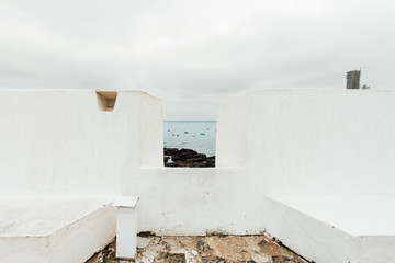 View of the sea with boats through the fort Sao Diogo wall in Salvador, Brazil