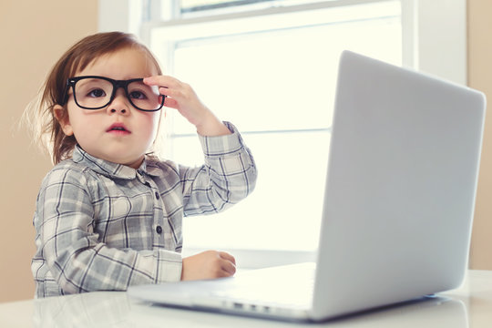 Little toddler girl using her laptop