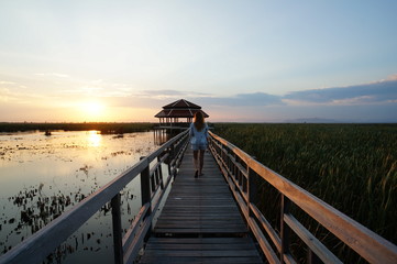 Fototapeta premium In the evening, a wooden bridge stretches to the lake,background