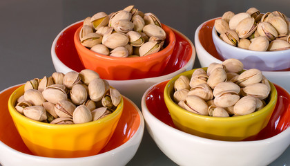 Appetizing snack calorie pistachio nut in colorful bowls