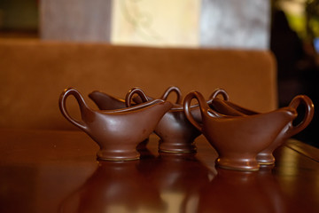Brown sauce boats on table