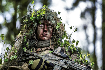 Camouflaged soldiers in forest © Piotr Jankowiak