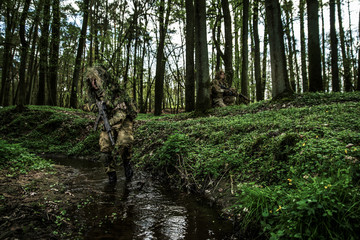 Camouflaged soldiers in forest © Piotr Jankowiak