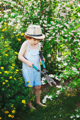 little boy watering the garden with hose