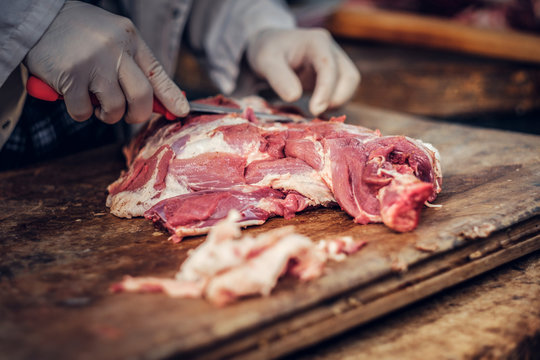 Close up image of a man cut fresh pork meat.