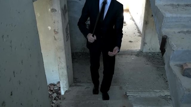 A man in a suit with a baseball bat in the building