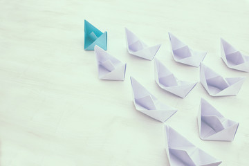 leadership concept, blue paper boat leading followers