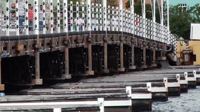 Details of the pontoons underneath the Queen Emma Bridge in Willemstad Curacao. Locals and tourists are walking across the bridge