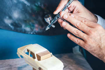 Person painting slot car with aerograph - 156126179
