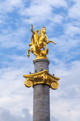 Fototapeta na wymiar Golden sculpture of Saint George on the Freedom Square in Tbilisi