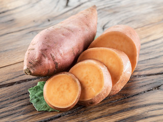 Sweet potatoes on the old wooden table.