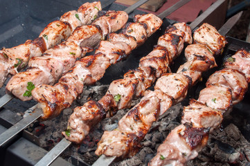 Extremely fried marinated meat on skewers over coals