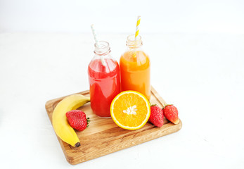 Juice in bottles. Banana, orange and strawberries. Top view. The concept of beverages, health food and vegetarian.